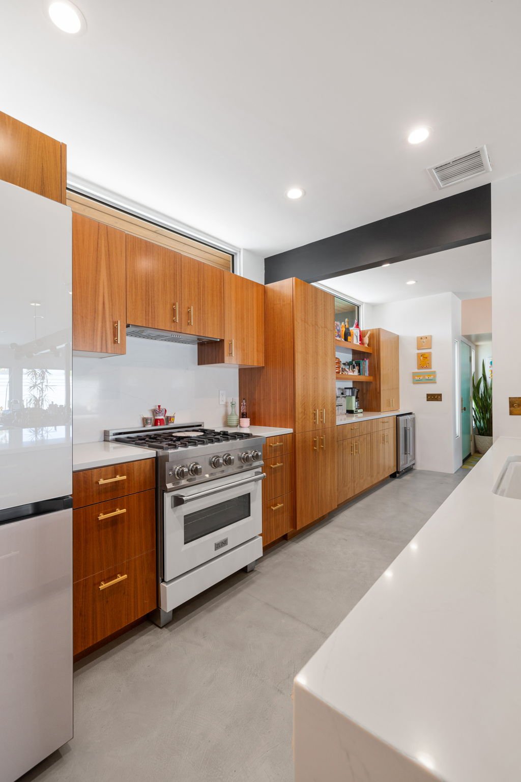 Galley corridor with walnut cabinetry both sides toward bar wall, Palm Springs kitchen